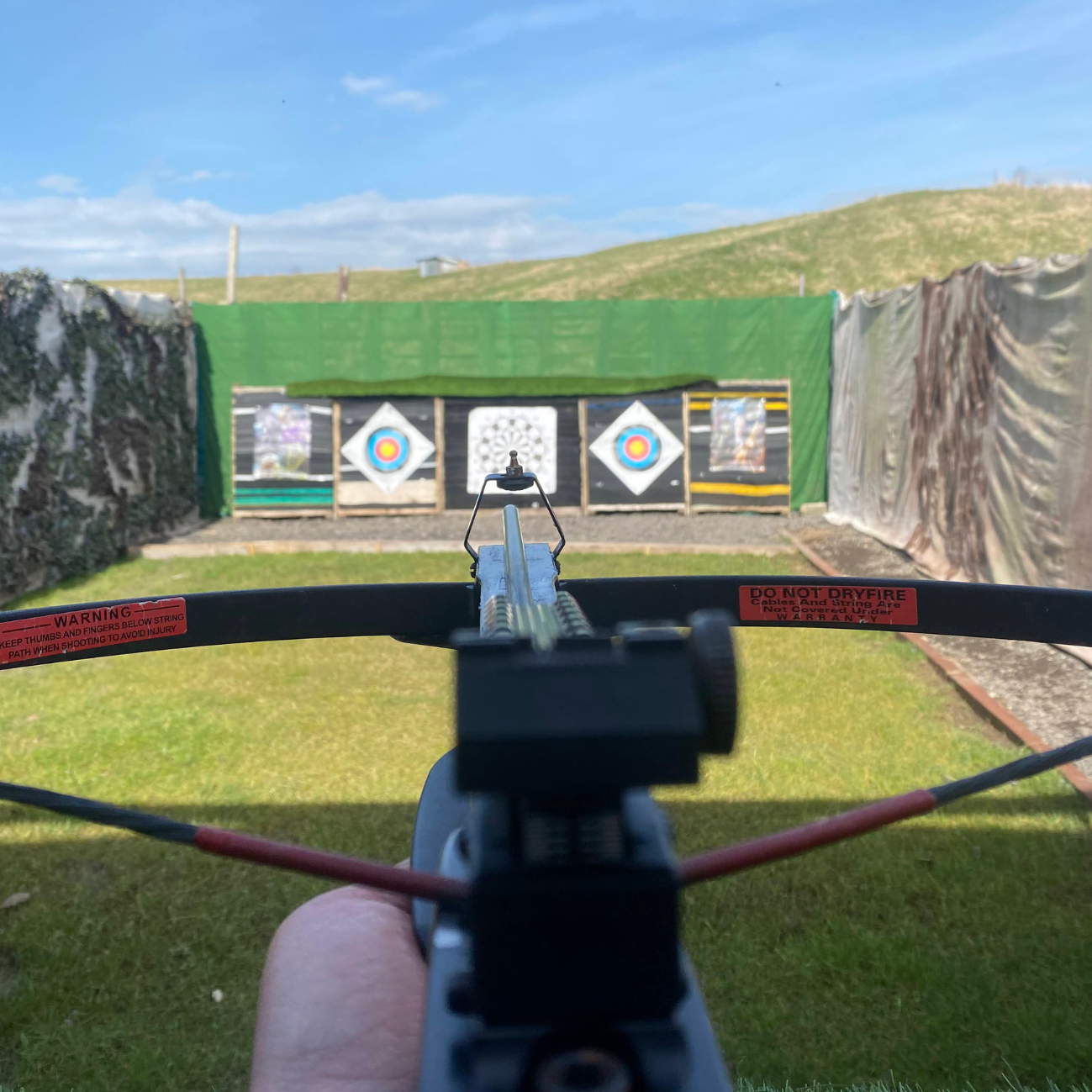 First-person view aiming crossbow at outdoor shooting range targets
