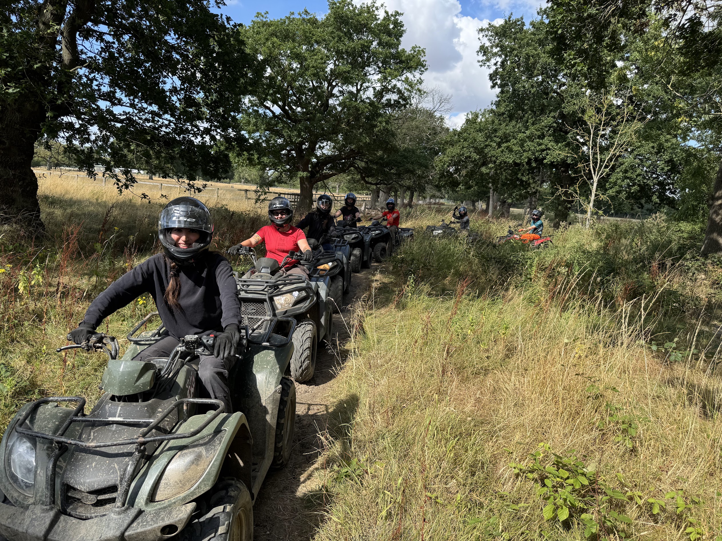 Group of riders quad biking single file along a countryside trail at Yorkshire Activity Centre near York